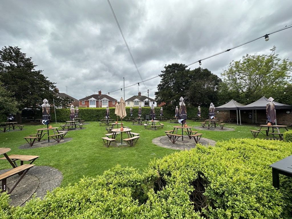 The beer garden at The Dockle Farmhouse in Swindon is huge, with dozens of tables and umbrellas across the grass.