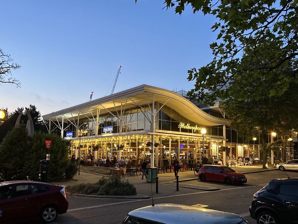 The exterior of Wetherspoons in Milton Keynes illuminated at night.
